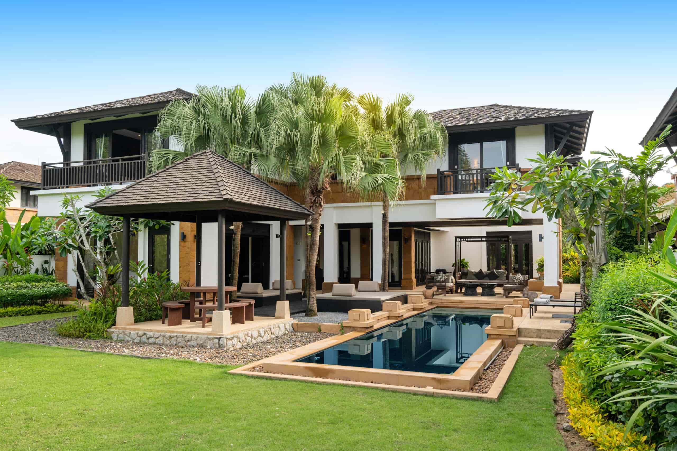 Luxury villa exterior with swimming pool, terrace, and landscaped garden in Dwarka